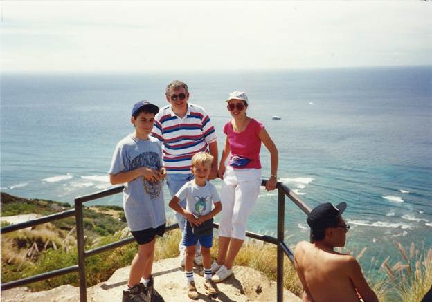 A group of people posing for a photo on a railing overlooking the ocean

Description automatically generated with low confidence