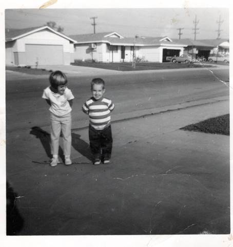 A couple of children standing in a driveway

Description automatically generated