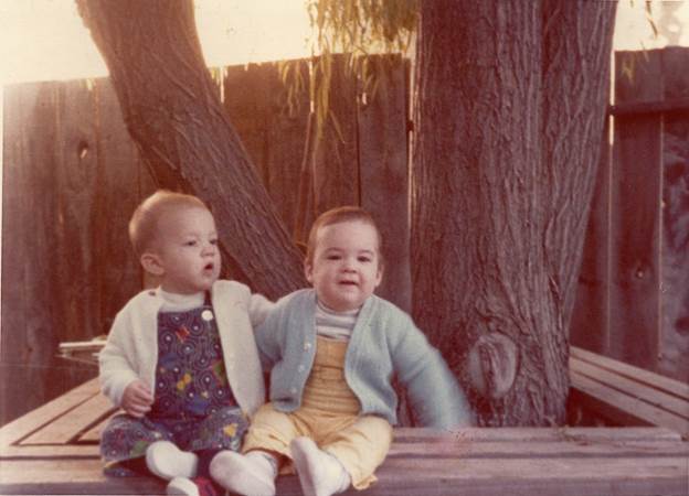 A couple of babies sitting on a bench

Description automatically generated