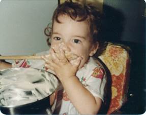 A child eating food in a highchair

Description automatically generated