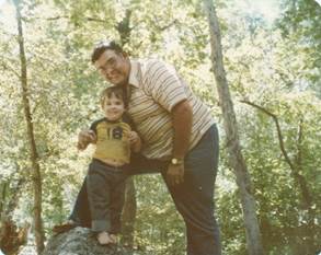 A person and child standing on a rock

Description automatically generated