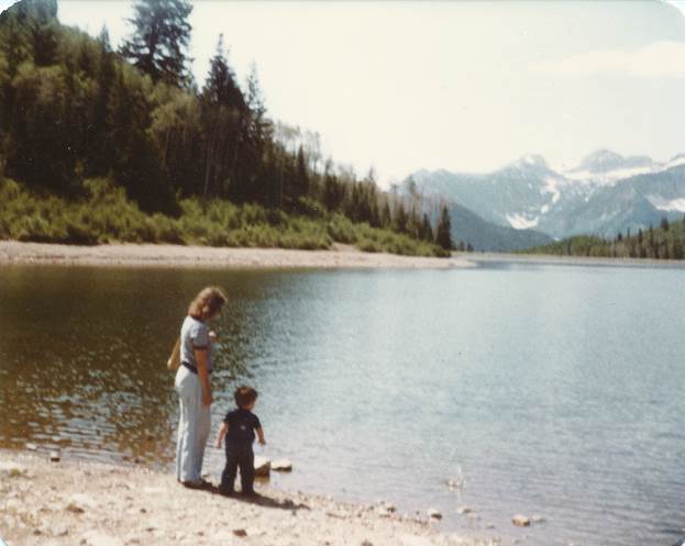 A person and child standing on a beach

Description automatically generated