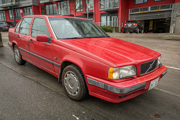 A red car parked on the street

Description automatically generated