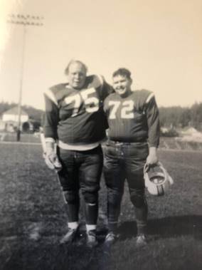 A couple of football players standing on a field

Description automatically generated