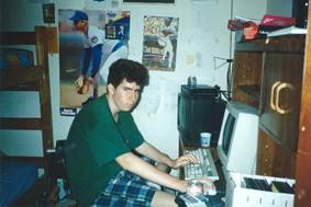 A person sitting at a desk using a computer

Description automatically generated