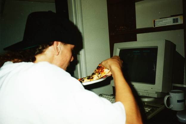 A person holding a plate of pizza

Description automatically generated